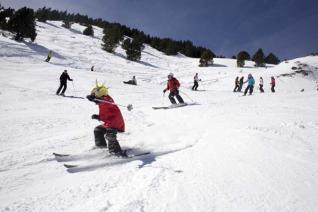 Pistes d'esquí amb un gruix de neu important i material aparcat a la zona de descans de la Molina. <br />