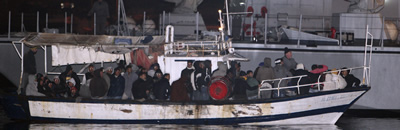 Una de les barcasses, plena fins a dalt d'immigrants, arriba al port de Lampedusa. (Foto: Reuters)