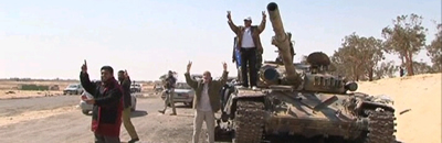 Els rebels celebren la victòria a Ajdabiya sobre un tanc destrossat de Gaddafi.