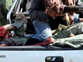 Un soldat presumptament lleial a Gaddafi, capturat en la part del darrera d'un vehicle. (Foto: EFE)