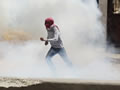 Un jove palestí corre envoltat de fum durant els enfrontaments amb la policia. (Foto: Reuters)