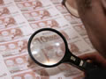 Un treballador examina bitllets de 10 euros. (Foto: Reuters)
