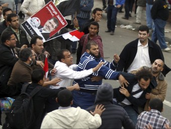 Partidaris del cap d'estat egipci, Mohammed Mursi, agredeixen un opositor, ahir davant del palau presidencial, al Caire Foto:KHALED ELFIQI/EFE