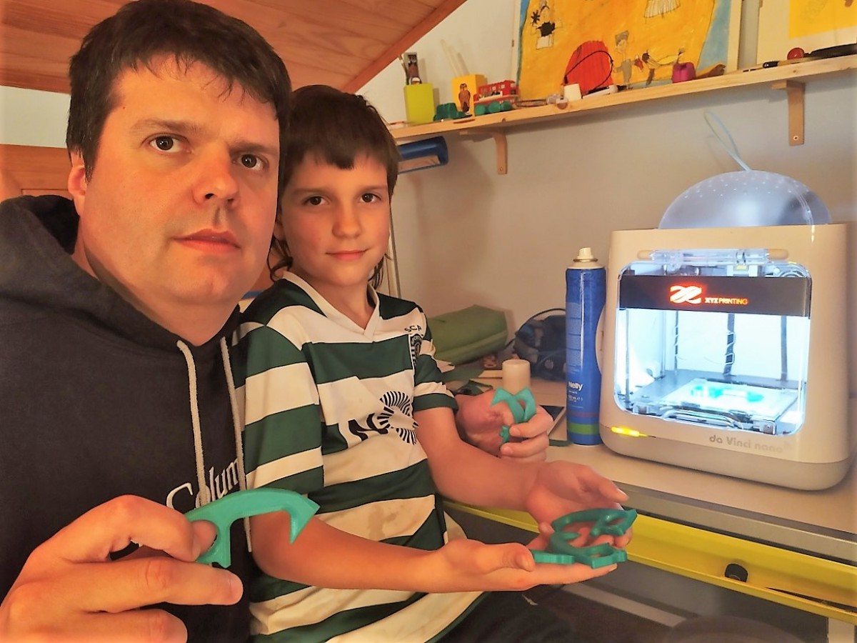 El Josep amb el seu fill, mostrant els mànecs  al costat de la impressora 3-D
