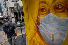 Un hombre pasa frente a un mural en Hong Kong.
