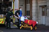 Dos trabajadores del King's College Hospital de Londres trasladan a un enfermo