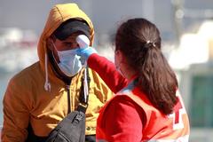 Una miembro de la Cruz Roja toma la temperatura en Algeciras