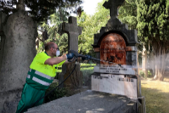Un trabajador limpia la tumba de Fernando Buesa.