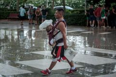 Un hombre protege a un bebé de la lluvia, en Valencia, en una imagen del pasado 14 de julio.