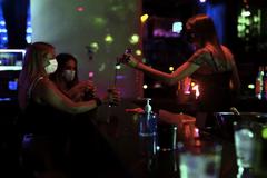 Una camarera atiende a dos clientas en la primera jornada de ocio nocturno en Madrid