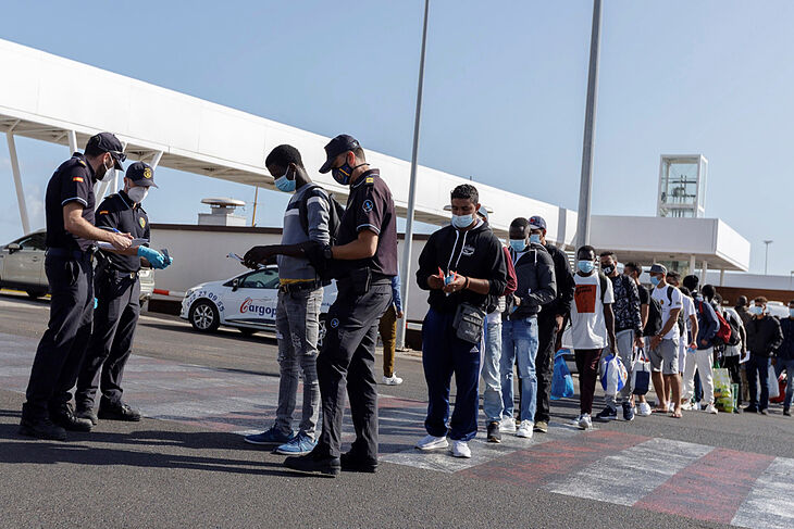 Policías piden su identificación a inmigrantes llegados al puerto de Santa Cruz de Tenerife.