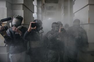 Periodistas con el rostro cubierto con máscaras antigás durante la cobertura del asalto al Capitolio.