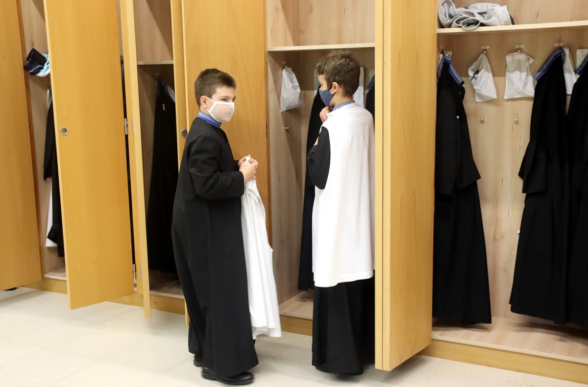 Dos escolans posant-se la roba per sortir a cantar a la Basílica de Montserrat