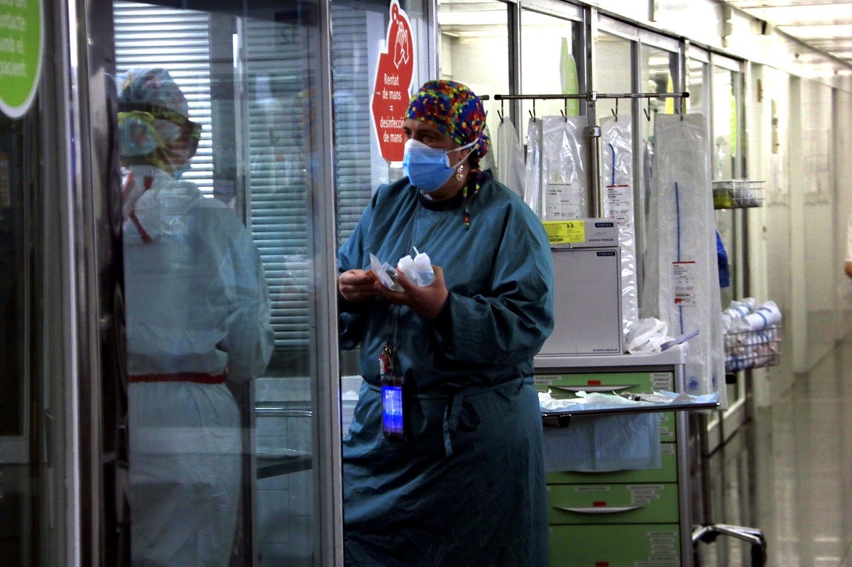 Sanitària portant material a una companya en una UCI de l'Hospital del Mar amb pacients Covid