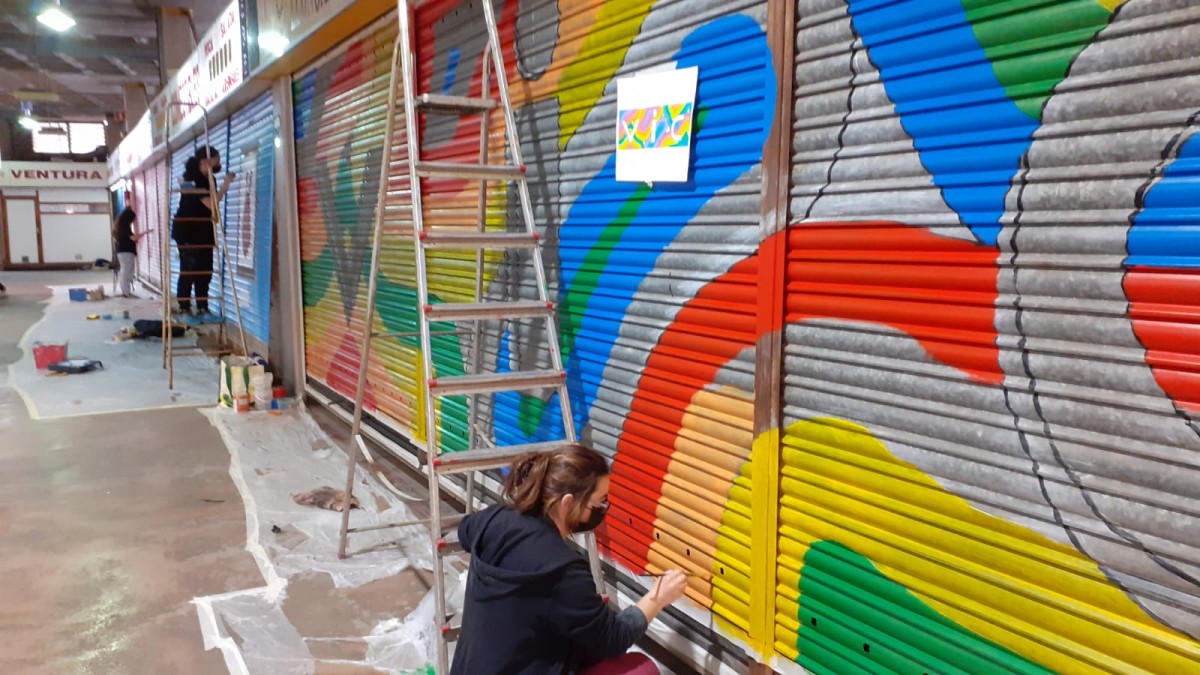 Alumnes de l'Escola d'Art d'Olot pinten les persianes del Mercat Municipal de Vic