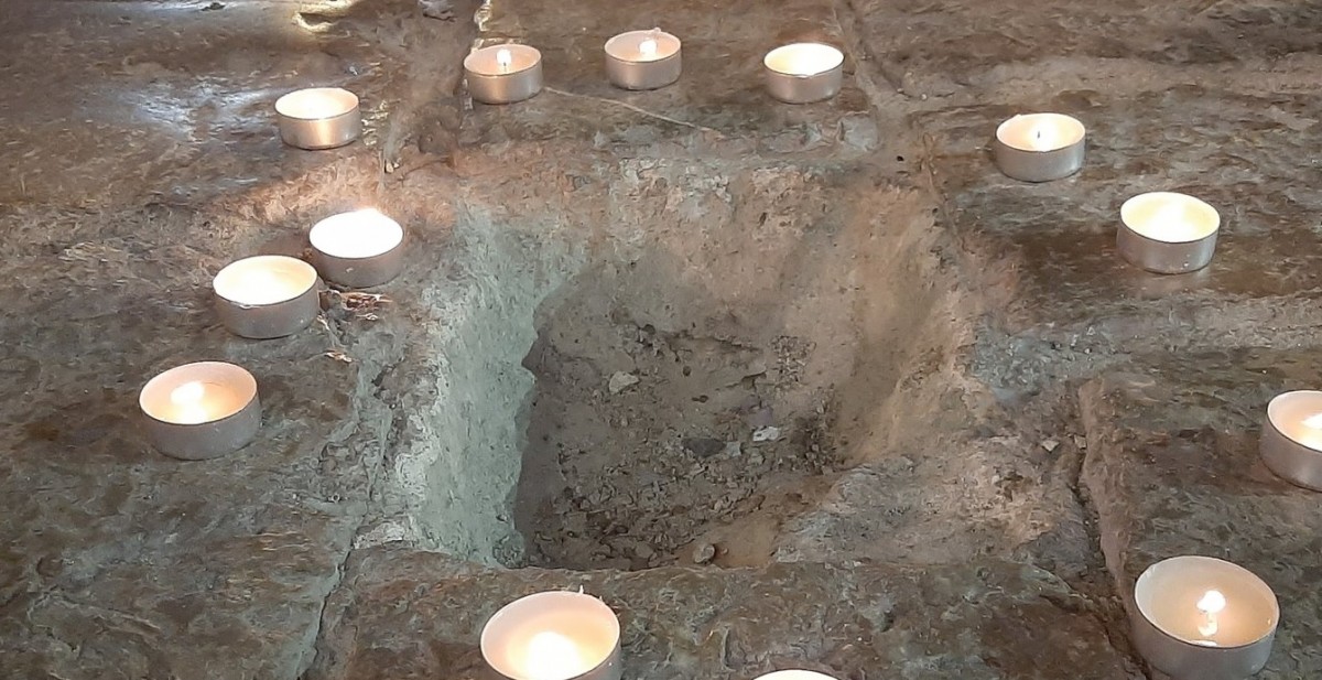 Una imatge del forat deixat per la llamborda, envoltat d'espelmes