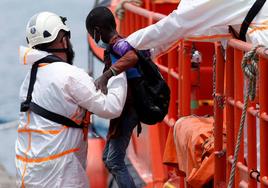 Un rescatista ayuda a un niño inmigrante a desembarcar en Arguineguín, Gran Canaria